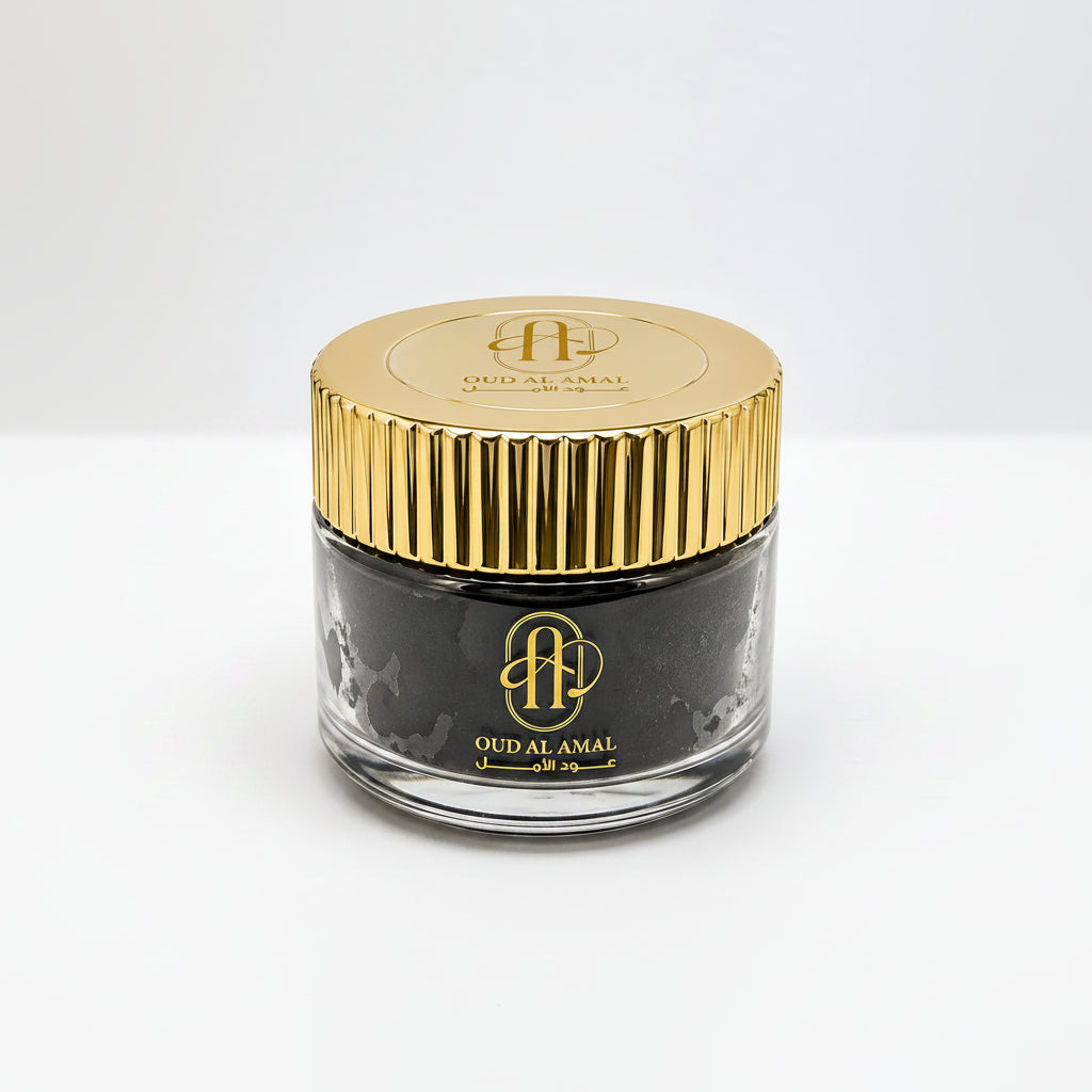 Jar of Oud Al Amal with gold lid on a white background