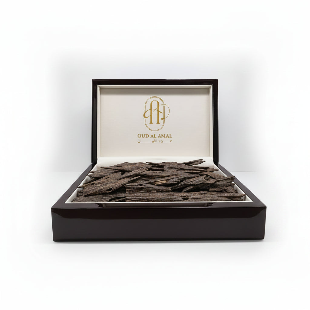 Oudwood pieces in a box with 'Oud Al Amal' branding on a white background