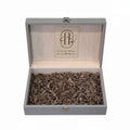 Gray box with Oud Al Amal oudwood inside on a white background
